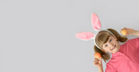 kid, child with rabbit ears showing Easter eggs
