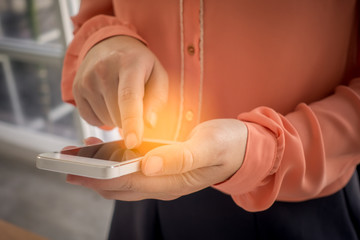 Woman's hand is holding and touching a smartphone