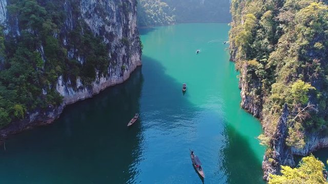 AERIAL. Beautiful top aerial view of group traditional thai boats sail between the huge mountains. Khao Sok national park in Surat Thani southern of Thailand. Similar to Guilin, China.