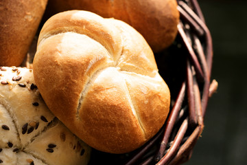Tasty freshly baked pastry with linseed and sunflower seed in a basket. Top view, copy space, selective focus. Pastries on a wooden table. Blurred background. Concept of fresh pastry.
