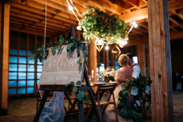 Wedding invitation. Lovers in a wooden gazebo. Evening, the lights are on.