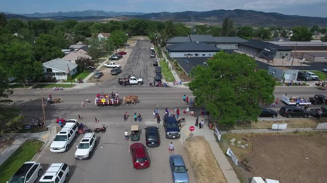 Moving away from a small town parade with horses.