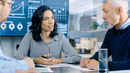 Group of Smart and Respectable Business People Work on a Problem Solving in the Meeting Room. Diverse Group of Mixed Ethnicity and Gender Explore Potential for Company Future Development.