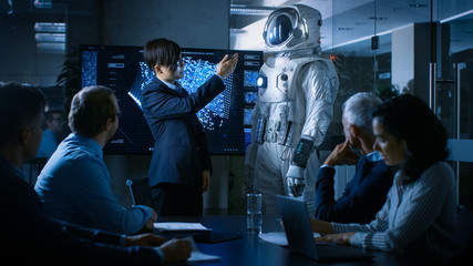 In the Conference Room of the Center of Technology Chief Engineer Presents Next Generation Space Suit to a Board of Directors. Completely Original Design with Integrated AI and Neural Network Systems. - obrazy, fototapety, plakaty