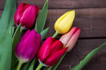 bouquet of tulips on dark brown boards
