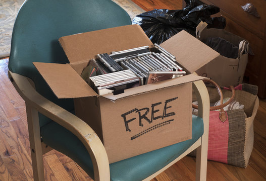 cardboard box marked free with CDs and DVDs on home table