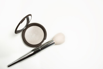 Closeup shot of pearl highlighter with makeup brush on a white background