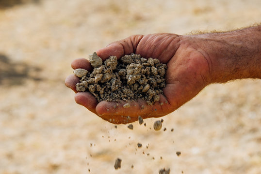 Mani uomo sostengono terra che cade