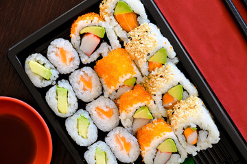 Große Sushi Takeaway Box mit Maki und California, Inside-Out Rolls mit Lachs , Avocado, Sesam und Fischroggen