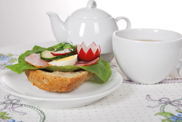 sandwich with lettuce ham with egg and radish with hot tea for a healthy breakfast