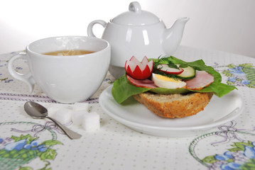 sandwich with lettuce ham with egg and radish with hot tea for a healthy breakfast