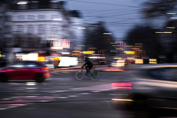 A cyclist drives at twilight over a road intersection