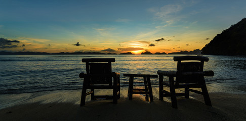 Philippines sunset on the beach with chairs an table