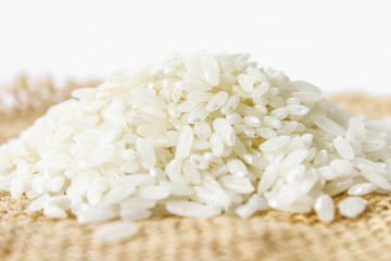 Grains of raw white rice on a white wooden table of boards. Ingredients for cooking.