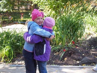 Girlfriends embracing in kindergarten outdoor