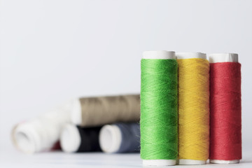 Accessories for sewing lie on a white background. Multicolored coils of threads.