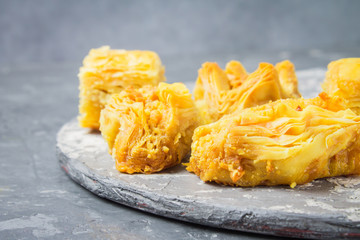 baklava turkish traditional delight on a dark wood background. toning.