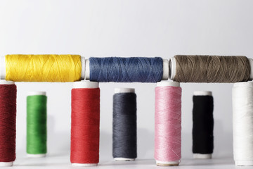 Set of colorful sewing threads on white background