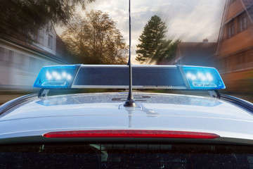 Polizeiauto mit Blaulicht im Einsatz im Wohngebiet