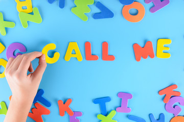 The girl puts out the phrase call me from colorful letters. Beautiful inscription .
