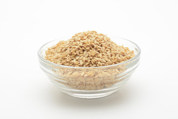 Lino dorado en un bol de cristal transparente sobre fondo blanco