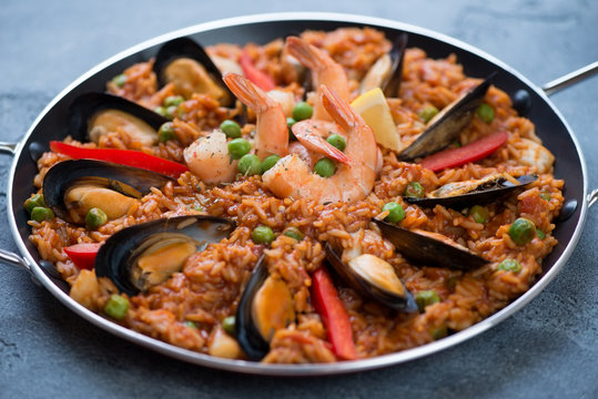 Spanish paella with seafood in a frying pan, selective focus, horizontal shot