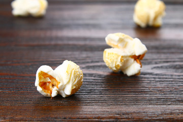 Seeds of salted popcorn on a wooden table.
