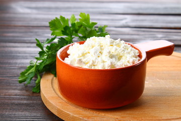 Home cottage cheese in a bowl on a wooden table.