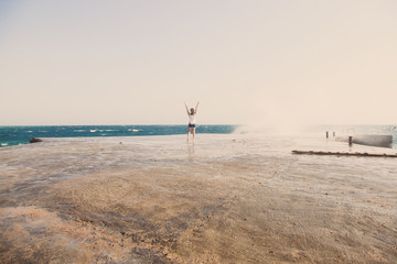 Свобода. Девушка радуется волнам на пирсе. 