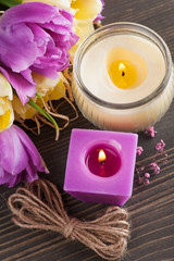 Obraz na płótnie Canvas Purple yellow tulips, lit candles