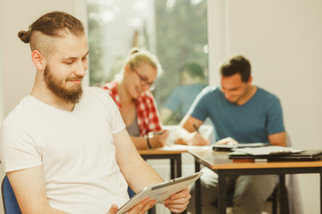 Fototapeta premium Student boy with tablet in front of her classmates