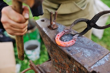 blacksmith makes horseshoe by tools