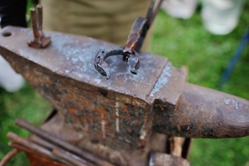 The smith makes a horseshoe on the anvil close-up