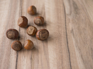 Hazelnuts on wooden background, left side, copy space