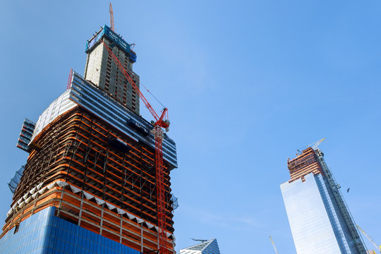 Construction Cranes On Construction Site Build Office Skyscraper Building In New York City At Sunset Time.