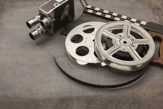 Old movie camera, film reels and clapperboards