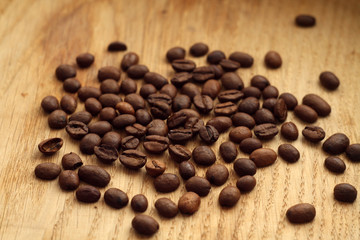 Coffee beans on wooden board with blur effect.