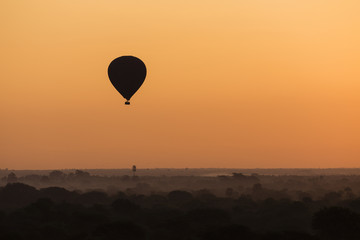 Scenic sunrise with a hot air balloon above Bagan in Myanmar.