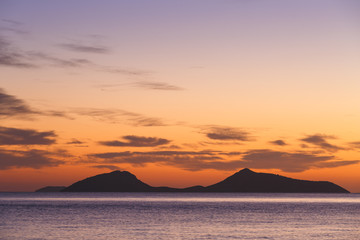 Naklejka na ściany i meble View of Trikeri island against colorful morning sky from Spetses, Greece. 