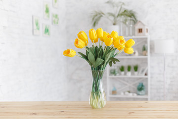 Tulips in a vase on a wooden table. Scandinavian interior.