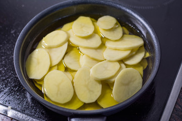 Cut potatoes in the pan with oil, making spanish omelette