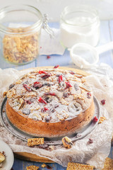 Banana cake with nuts, sesame and cranberry on a wooden table