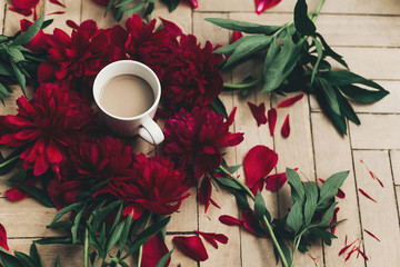 modern floral instagram blogging image. stylish coffee and beautiful red peonies on rustic wooden background flat lay. space for text. happy womens day or mothers