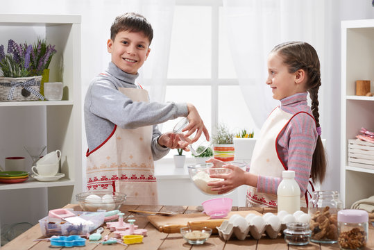 Girl and boy cooking in home kitchen, make the dough for baking, healthy food concept