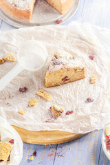 A piece of banana cake with nuts, sesame and cranberry on a wooden table