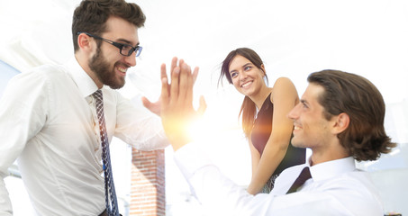 business colleagues giving each other high five.