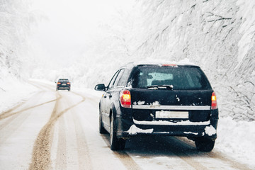 Obraz na płótnie Canvas Car driving on snowy road in winter
