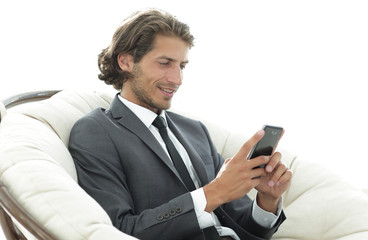 successful business man with a smartphone sitting in a comfortable chair