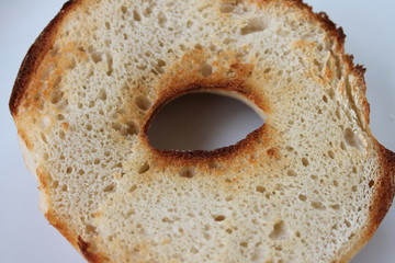 Half of a plain toasted bagel close up.
