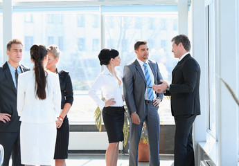 group of business people talking,standing in the lobby of the office.